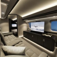 the inside of an airplane with a flat screen tv on it's wall and couches