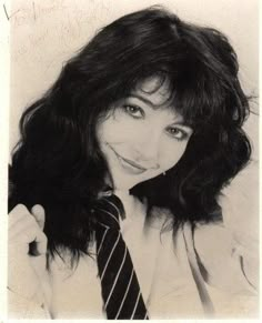 black and white photograph of a woman with long hair wearing a shirt and striped tie