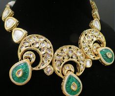 This beautiful choker is a modern twist to traditional jewelry and comes in a gold finish with green stones to match any outfit as desired. The choker is made of high quality stones and is a statement piece that can be dressed accordingly. The set comes with matching earrings for a complete look. Formal Green Kundan Necklace With Jewels, Green Kundan Necklace With Jewels For Formal Occasions, Fusion Style Green Bridal Necklace With Stone Work, Green Formal Bridal Necklace In Chandbali Style, Green Fusion Bridal Necklace With Stone Work, Green Chandbali Bridal Necklace For Formal Occasions, Traditional Gold Emerald Necklace For Parties, Green Chandbali Necklaces For Party, Party Green Gold Plated Jewelry Sets