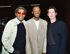 three men standing next to each other at an event