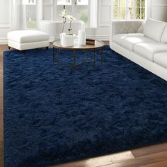 a living room with white furniture and blue carpet