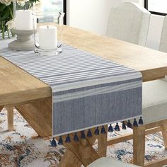 a dining room table with a blue and white striped table runner on top of it