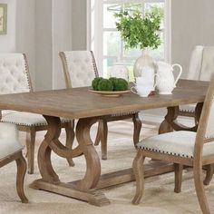 a dining room table with white chairs around it