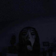 a person with their mouth open in the dark