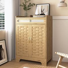 a wooden cabinet sitting next to a window in a room with white walls and wood flooring