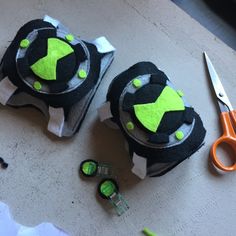 two pieces of fabric with green and black designs on them next to scissors, tape measure and pliers