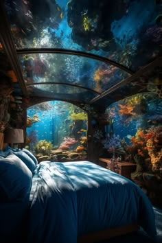 a bed room with a large aquarium wall mural on the ceiling and a bed covered in blue sheets