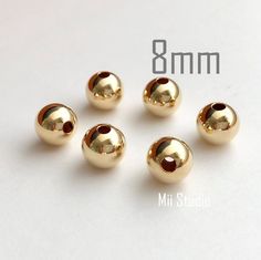 gold plated round beads are shown on a white surface with the number 8mm