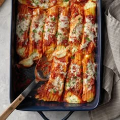 a blue casserole dish filled with pasta and sauce, garnished with parmesan cheese