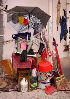 an umbrella and other items are piled up on the floor in front of a building