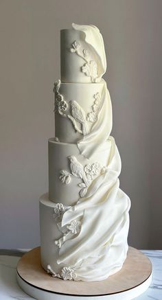 a three tiered wedding cake with white frosting