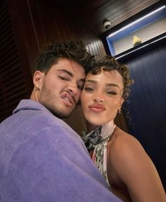 a man and woman wrapped up in towels posing for the camera with their eyes closed