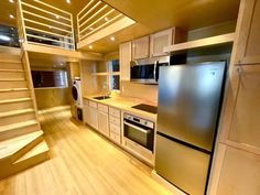 an empty kitchen with stainless steel appliances and stairs