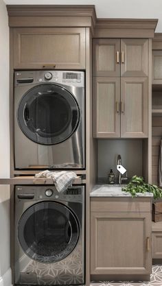 a washer and dryer in a room with wooden cupboards on the wall