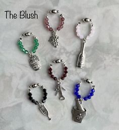 six different bracelets with charms on them sitting on a white table top next to each other