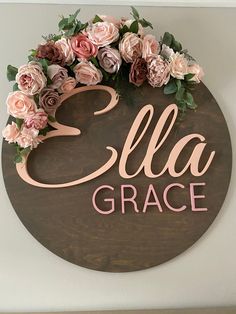 a wooden sign that says ella grace with pink flowers on the front and back of it