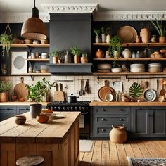 a kitchen with lots of pots and pans on the shelves above the stove top