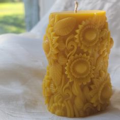 a yellow candle sitting on top of a white bed