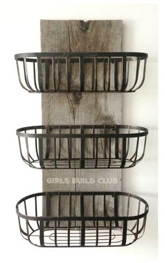 three metal baskets are hanging on the wall