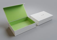 an open white box with a green lid and bottom is sitting on a gray surface