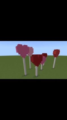 some red and pink trees in the middle of a grassy field with blue sky behind them