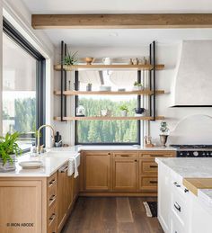 a kitchen filled with lots of wooden cabinets and counter top space next to a window