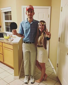 the man and woman are standing in front of the kitchen counter posing for a photo