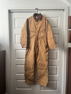 "Amazing piece of vintage workwear history! These amazing Carhartt coveralls are union made in the USA. Made of thick, heavy weight canvas (100% cotton) and quilt lined with a gorgeous red 100% nylon for warmth. The coveralls have a front zip closure with snap-button storm flap. Additionally each leg has ankle-to-waist zippers and snap closure. In case you thought it couldn't get any better bad boy is machine washable! In excellent vintage condition. 🔸Flaws (see images): General overall wear and some small minor marking 🔸Measurements are taken with the garment lying flat - Chest: 26\" - Length: 59.5\" - Sleeve Length: 34\" - Crotch to chest: 34\" Please view the full listing details carefully as all sales are final and items are sold \"as is\". These items are all second-hand but I will Cotton Overalls For Outdoor Fall Activities, Vintage Brown Cotton Overalls, Cotton Long Sleeve Overalls For Winter, Carhartt Coveralls, Coveralls Workwear, Mechanic Coveralls, Vintage Mechanics, Insulated Coveralls, Thrift Inspo