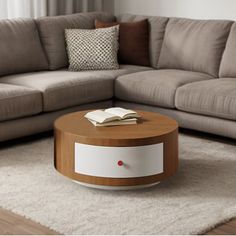 a living room with a couch, coffee table and book on the floor in front of it