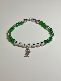 "This is a handmade beaded bracelet for all those boy moms out there!! Very cute green and silver color with words \"Boy Mom\" and a cute little boy accent charm on a stretchy elastic with clasp. Would fit a 7\" wrist or bigger easily.   The silver beads really make the charm shine! Picture taken in different lighting to show how it looks under different settings. We offer free shipping on all of our items! If you are interested in a certain color combination, please send me a private message to Handmade Green Charm Bracelet For Gift, Handmade Green Charm Bracelet Gift, Casual Nickel-free Charm Bracelet As Gift, Green Letter Beads Jewelry For Birthday, Personalized Green Bracelets As Gifts, Casual Nickel-free Beaded Bracelets As Gift, Green Jewelry With Letter Beads For Birthday, Personalized Silver Charm Bracelet Casual Style, Personalized Silver Charm Bracelet