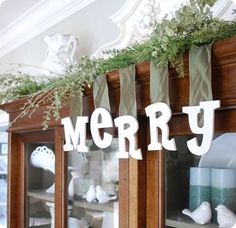 a display case filled with christmas decorations on top of a wooden shelf next to a window