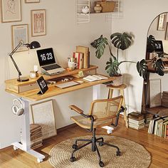 a desk with a laptop on top of it next to a chair and bookshelf