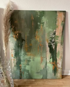 an abstract painting with green, orange and brown colors on it next to a vase