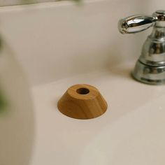 a bathroom sink with a wooden soap dispenser