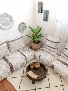 a living room filled with lots of furniture and decor on top of a white rug