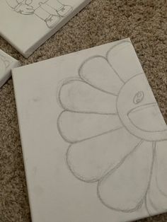 three drawings on the ground with one drawing of a flower and another drawing of a bird