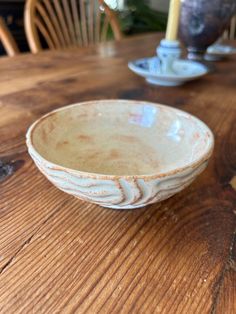 a white bowl sitting on top of a wooden table