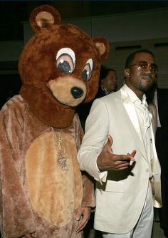 a man in a bear suit standing next to another man wearing a teddy bear costume