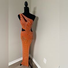 a mannequin is dressed up in an orange dress with sequins on it