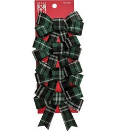 the green and black plaid hair bow is packaged in a package with red tag on it