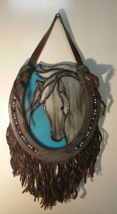 a wall hanging with a horse on it's face and fringes around the edges