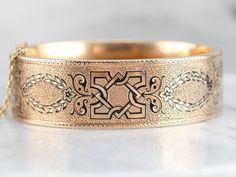 This antique bracelet is in excellent condition, with very little wear to the beautiful gold. The black enamel pattern and fine engraving on the top are intricate and in great condition! The inside of the bangle has the original monogram, the name of the owner in a beautiful French script. The polish is soft and creates a lovely texture on the wrist. Metal: 14K Antique Rose Gold Material: Black Enamel Width: 19 mm Inside Circumference: 6 Inches Marks: "CARRIE G. LECMAN" Engraved Luxury Victorian Bangle With Intricate Design, Luxury Victorian Etched Bracelets, Luxury Engraved Victorian Jewelry, Luxury Traditional Enamel Bracelet, Luxury Etched Gold Bracelet, Luxury Designer Bracelets With Black Enamel, Luxury Victorian Bangle For Anniversary, Luxury Antique Bangle Cuff Bracelet, Luxury Antique Engraved Cuff Bracelet