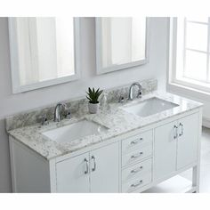 a bathroom with two sinks and mirrors on the wall next to each other in front of a window