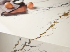 some eggs are sitting on top of a marble countertop that has been stained white and gold