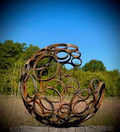 a metal sculpture sitting in the middle of a field