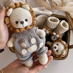 a hand holding a small stuffed animal next to other crocheted animals in a basket