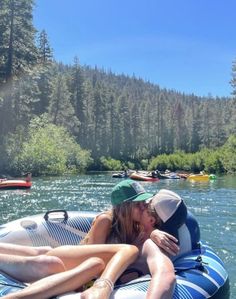 two people are laying on an inflatable raft and one is kissing the other