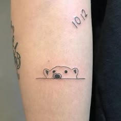 a tattoo with a polar bear on it's arm and numbers in the background