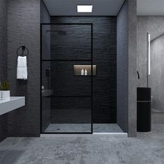 a black and white bathroom with a glass shower door, toilet and sink in it