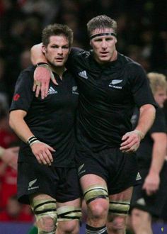 two rugby players hugging each other on the field